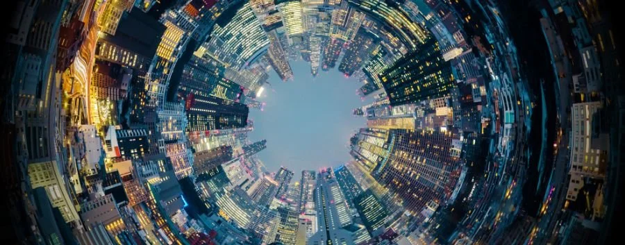 360 photo of a view of a city at night from the ground looking up at the sky and buildings from below